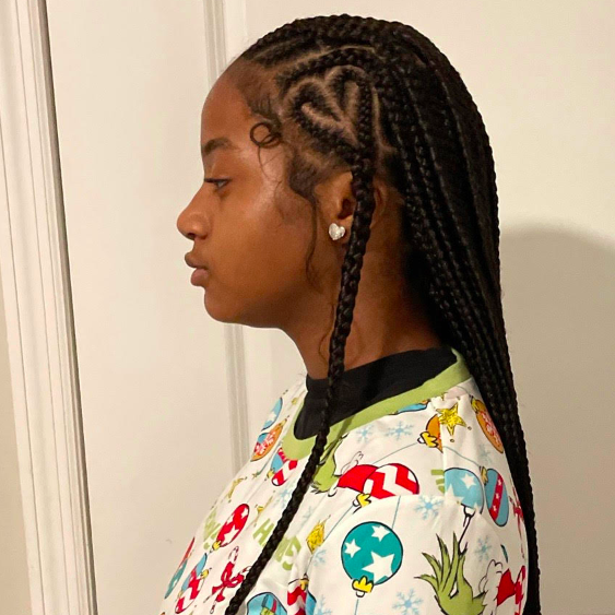 Teenage girl with knotless platts. It forms a heart shape on her temple