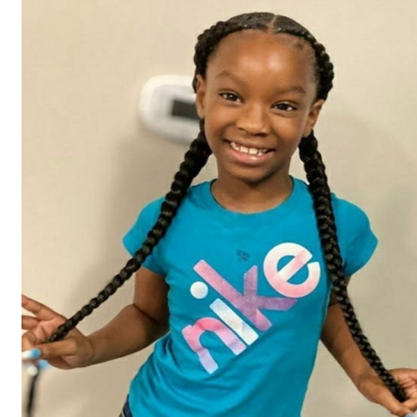 Young girl with two large braided pigtails.